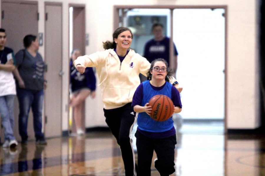 Life Skills instructor Lauren Hanratty runs alongside Special Olympics basketball player Jada Miller during the schools first basketball event on Tuesday, Feb. 5, 2019 in the competition gym. 