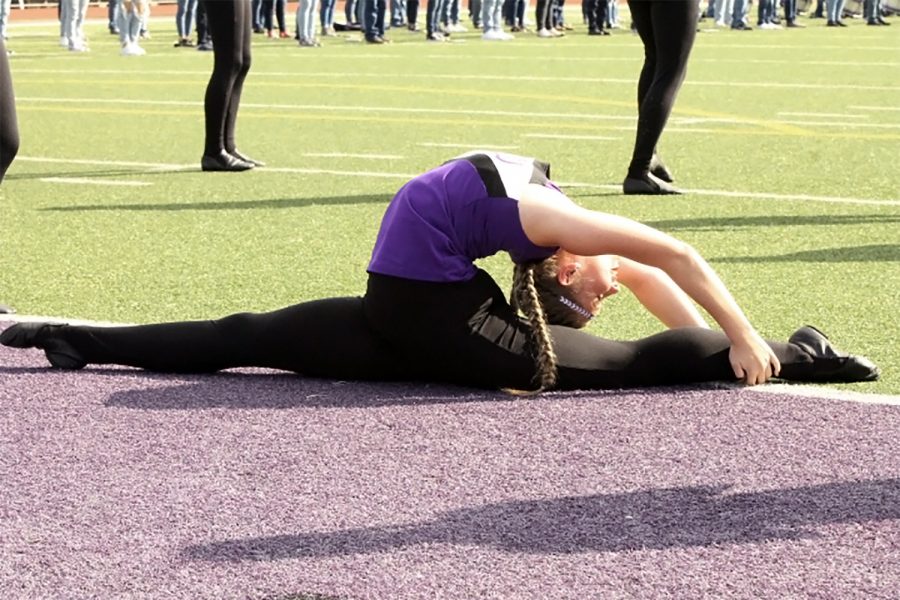 Indianette Peyton Hudgins, sophomore, stretches near the end zone as the squad waits before the start of the Dayton pep rally on Friday, Oct. 30.