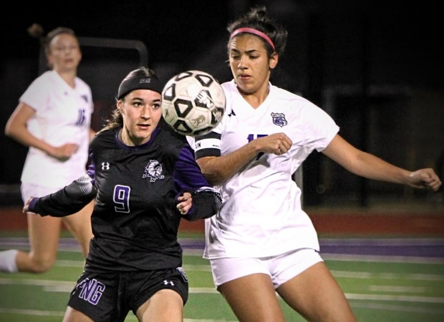 Varsity soccer player Addison Blotner (25) eyes the ball as it floats in front of her while fighting for position against a College Station defender during the first night of the Cajun Classic girls soccer tournament. PNG hosts the tournament annually and this year had the largest field ever, with 16-teams playing games on three-straight days on three adjacent fields. (Charlie Garza/NDN Press)