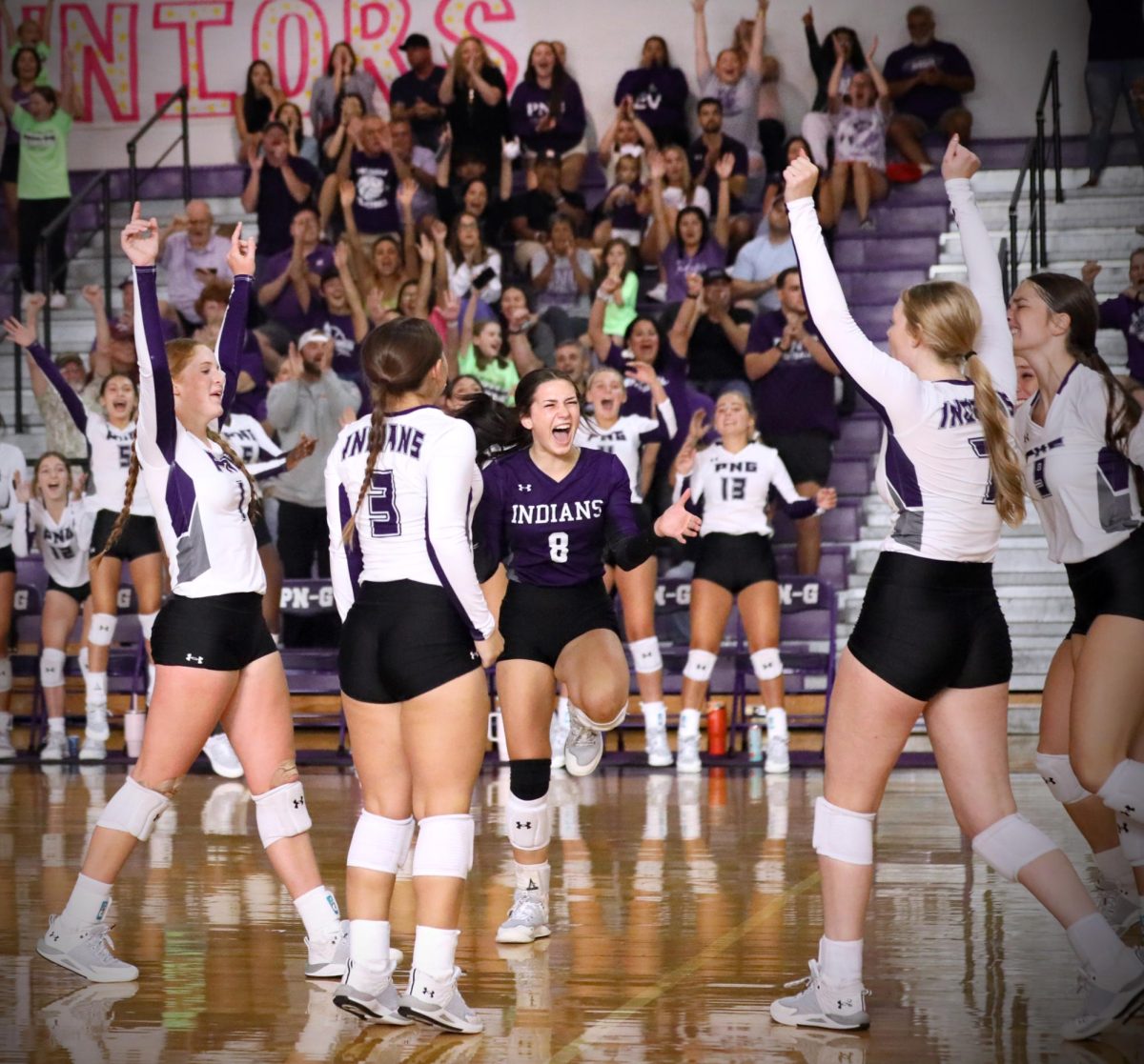 Varsity libero Karleigh Gil ('25) is surrounded by the rest of the Rock-A-Noos as they celebrate scoring match point against West Brook, giving the team its first home win of the season on Tuesday, Aug. 15. The win was the first of the non-district season for the team — as well as the first under new head coach Allie McDaniel. (Gilberto Moreno Flores/NDN Press)