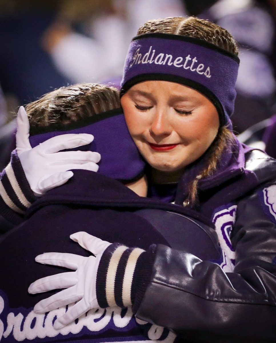 With the clock running out of the Class 5A-II state quarterfinal game with South Oak Cliff, Indianette officer Samantha Simon ('25) embraces Laurel Bradberry ('26) as the football season comes to an end with a 14-56 loss at Stephen F. Austin State University on Friday, Dec. 2, 2024. The loss not only ended the football season, but the performance season for the drill team. (Celia Ruiz/NDN Press)