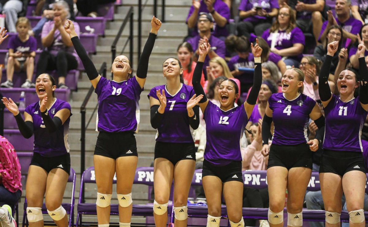As the Rock-A-Noos settle in for match point against rival Nederland, the bench erupts in cheer at the prospect of the first season-sweep against the Mid-County foe in more than a decade on Tuesday, Oct. 7, 2025 in the competition gym. PNG went on to sweep Nederland, 3-0 as the second round of district play began. (Payton Bryan/NDN Press)