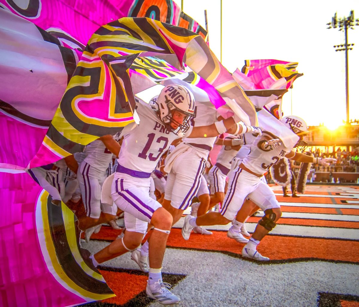 Advanced News Photo Ella Owens Port Neches-Groves High School Port Neches, TX Mike Tobias, Instructor  Connor Bailey ('26) focuses on the field ahead as he leads the team out of the inflatable tunnel and through the cheer banner as the varsituy football team takes the field ahead of the game at La Porte on Friday, Sept. 12, 2025.   Heading into Week 3, both the Indians and Bulldogs were undefeated in a matchup many statewide pundits anticipated to be close.  The Indians scored first and never looked back and finished the game with a 35-21 win. (Ella Owens/NDN Press)